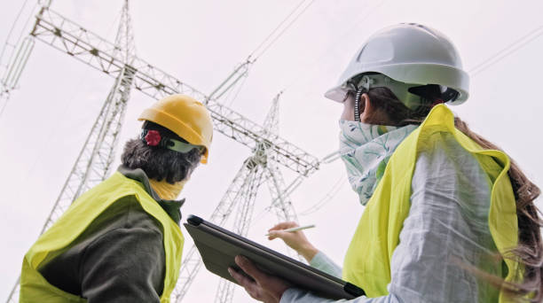 istock High voltage engineers working on the field in COVID-19. Teamwork. 1472187798