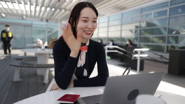Young businesswoman joining online meeting from airport observation deck