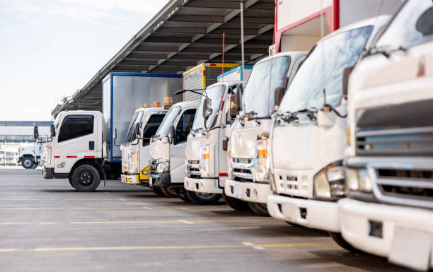 camion parcheggiati in un magazzino di distribuzione pronti a consegnare alcune merci - camion foto e immagini stock