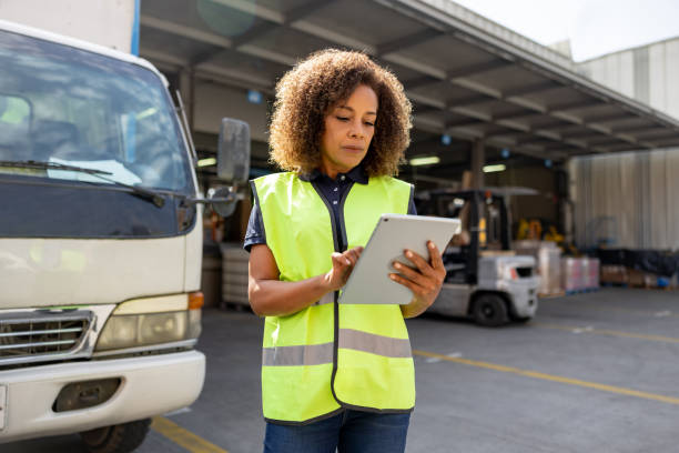 物流倉庫でトラックの配車を監督する女性 - commercial land vehicle 写真 ストックフォトと画像