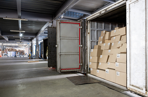 Merchandise packed in boxes in trucks and ready for delivery at a commercial dock - freight transportation concepts