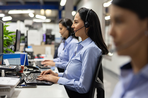 Group of Latin American women working as customer service representatives at a call center
