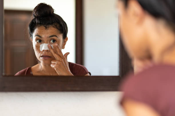 istock Woman applying pore strips on nose in bathroom 1472202511