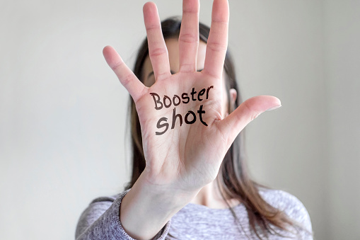 Booster shot reminder note in woman’s palm