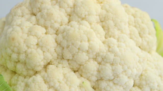 Close-up of whole head of the fresh raw cauliflower on white background. selective focus. Rotating on white background.