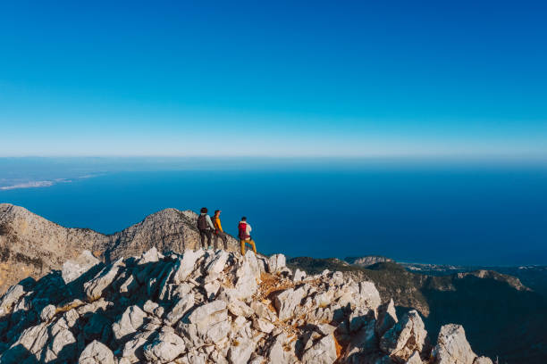 summiteers sulla cima della montagna, punto di vista del drone - exploration mountain teamwork mountain peak foto e immagini stock