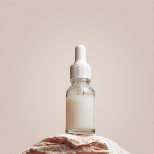 Glass dropper bottle with white liquid essence, serum, cream on stand from natural stone, minimal beige gradient background. Natural Cosmetic, monochrome aesthetic mockup cosmetic product Glass dropper bottle with white liquid essence, serum, cream on stand from natural stone, minimal beige gradient background. Natural Cosmetic, monochrome aesthetic mockup cosmetic product for skincare makeup product photography stock pictures, royalty-free photos & images