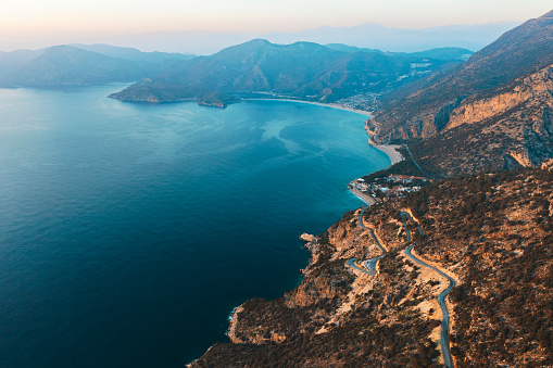Mountain and winding road at sunset at the sea, drone point of view, Fethiye