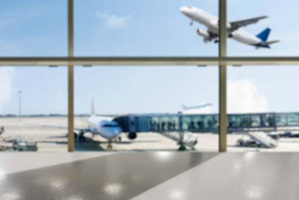 Empty airport terminal hall with an airplane in the background. Blurred background.