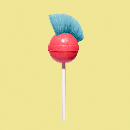 Crazy fun candy on a stick with a mohawk hairstyle. Minimal concept of daring and surreal lolly. High quality photo