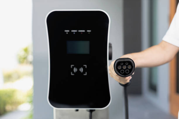 istock Focus closeup hand pointing EV plug for electric vehicle as progressive idea. 1472225169