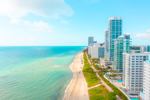 Amazing turquoise ocean water on a white sand beach in Miami Beach Florida USA Modern waterfront architecture on display with blue ocean water and white sand miami beach stock pictures, royalty-free photos & images