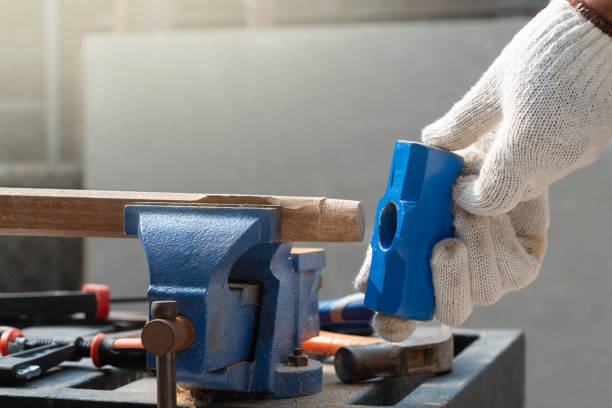 istock Male hobby retirement. Senior man is using bench vise on wood  for assembling hammer handle. 1472229104