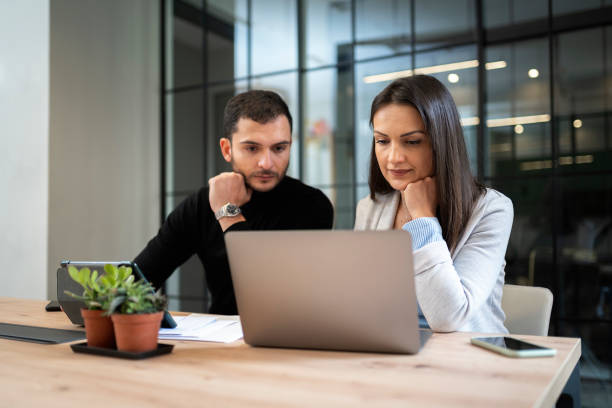 istock Happy couple using laptop in office 1472231620