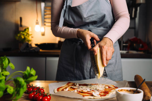 istock woman prepares pizza at home 1472233850