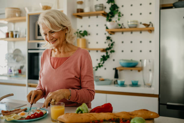 istock Mature woman making morning breakfast 1472235615