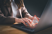 Businesswoman or programmer using computer laptop with triangle caution warning sign for notification error. Concept of computer virus detected, personal data protection, network security, maintenance