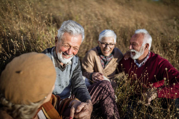 istock Happy seniors talking during autumn day in tall grass. 1472240529