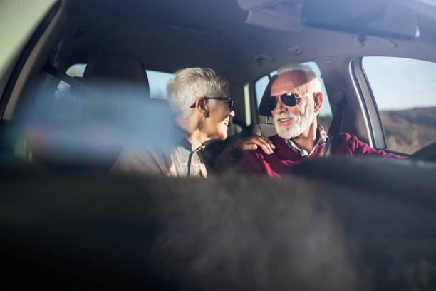 istock Happy senior couple talking while going on a trip by car. 1472240541
