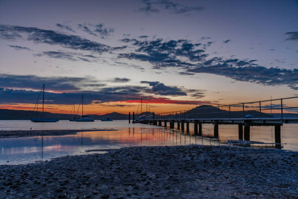 istock Sunrise waterscape with wharf, boats and clouds 1472242850