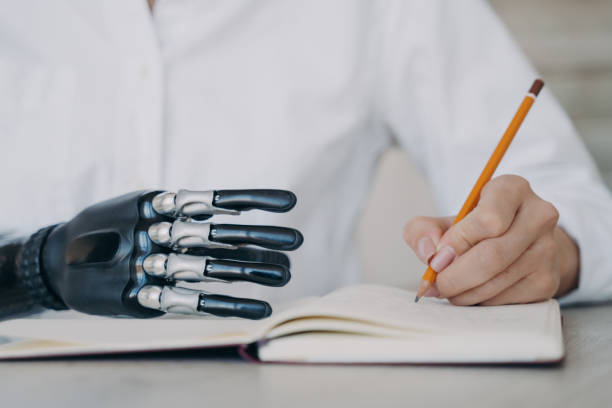 istock Cyber arm and healthy limb on the notebook. Woman with bionic prosthesis is studying remotely. 1472244407