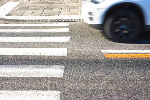 Black and white pedestrian crossing with car on background - image with copy space