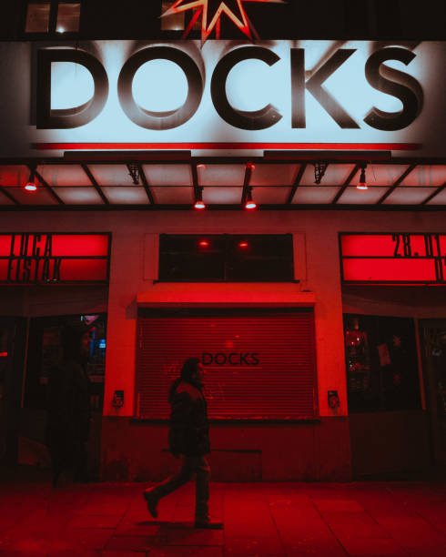 Famous Night Club at Redlightdistrict, Hamburg Reeperbahn. One Person walking down the street in front of the famous hamburger nightclub. Red  colors and moody atmosphere with streetlights. Picture was shoot in the late evening.