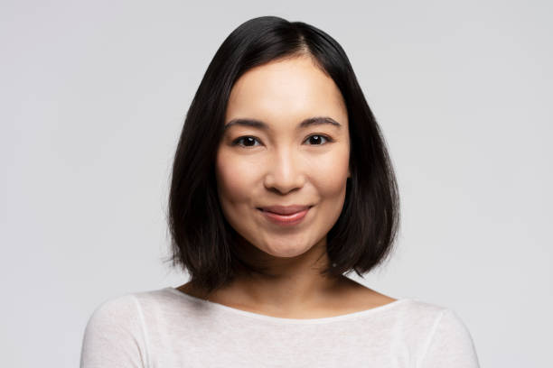 istock Pretty smiling joyfully female with brunette hair looking with satisfaction at camera 1472247014
