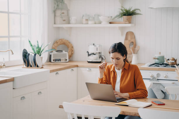 istock Female sales manager is working from home. Lady freelancer with laptop is taking notes. 1472249217
