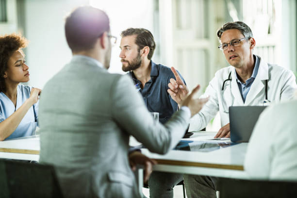 istock Doctors and businessmen talking on a meeting in the office. 1472249607