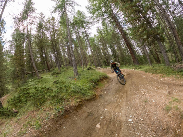 istock Riding down the mountain through the forest, male mountain biker on the move 1472249642