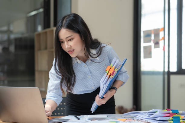 Businesswoman working with a pile of documents.