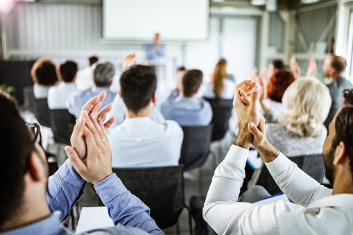 Businessmen applauding with their colleagues during successful business seminar in a board room.