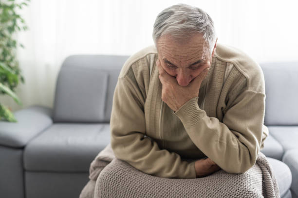 istock Frustrated unhappy middle aged mature man sitting on sofa, feeling depressed alone at home. Confused senior retired grandfather worrying about difficult life decision, copy space, old people solitude 1472250655