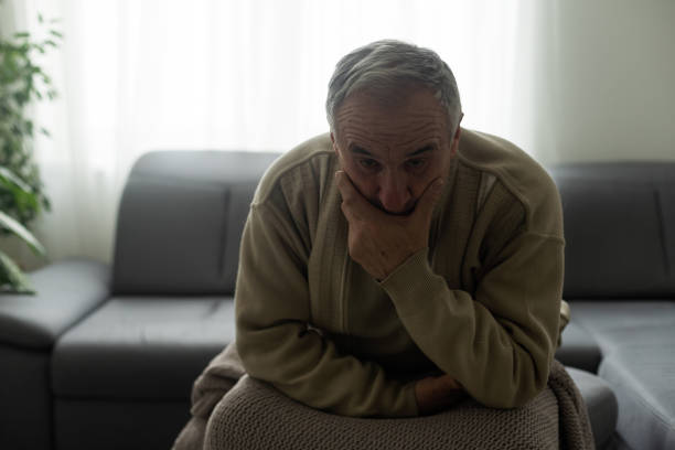 istock Frustrated unhappy middle aged mature man sitting on sofa, feeling depressed alone at home. Confused senior retired grandfather worrying about difficult life decision, copy space, old people solitude 1472250901