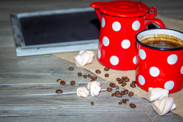 Black coffee in a white mug with cinnamon sticks on a saucer on a grey table