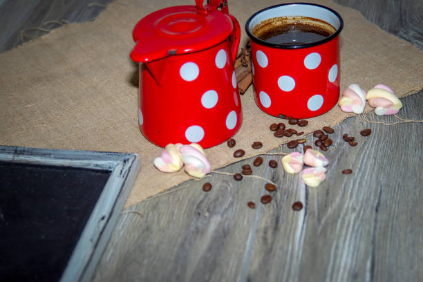 Black coffee in a white mug with cinnamon sticks on a saucer on a grey table