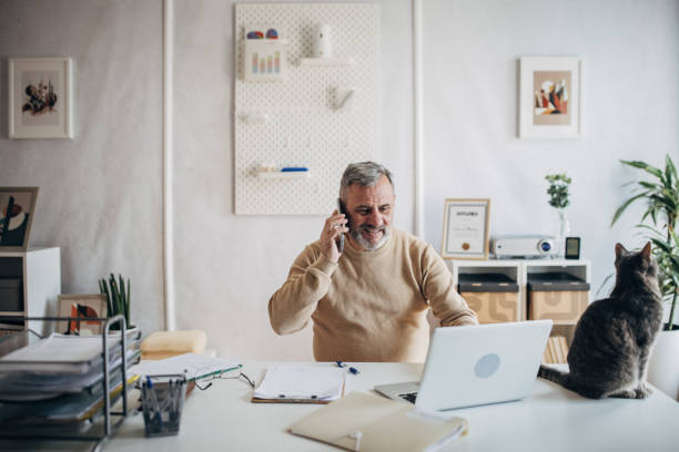 istock A pet cat in the office of an active older man 1472253313