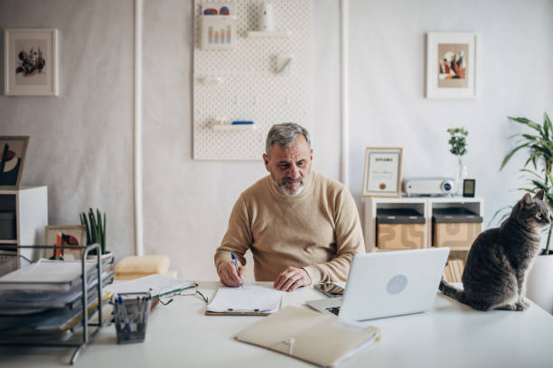 istock A pet cat in the office of an active older man 1472253576