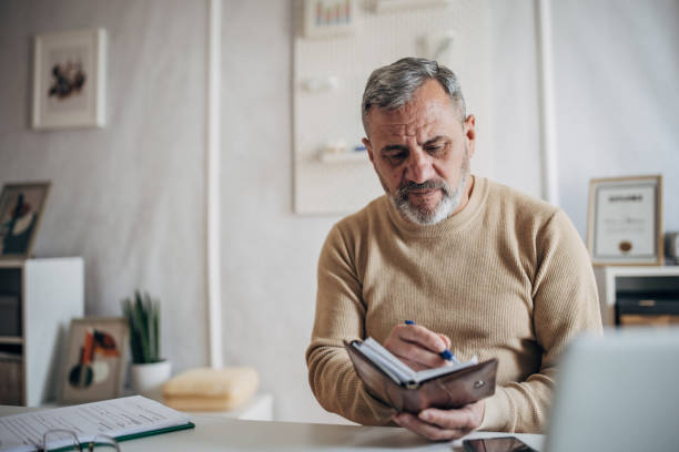 istock An elderly man with a beard goes to the office to work, uses a reminder 1472253614