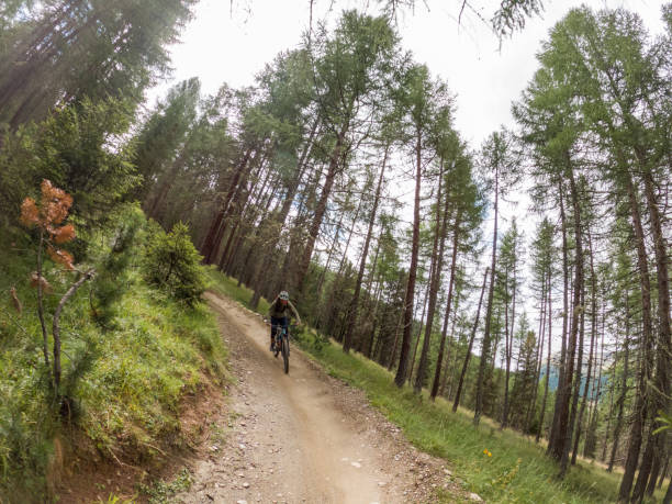 istock Riding down the mountain through the forest, male mountain biker on the move 1472254680