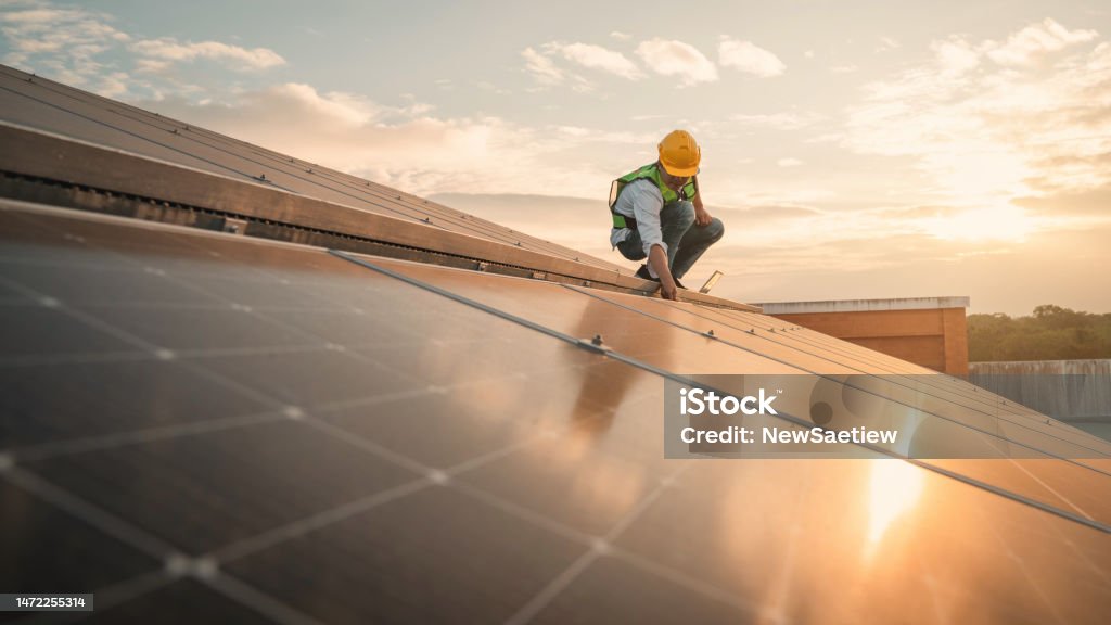 Service engineer checking solar cell on the roof for maintenance if there is a damaged part. Engineer worker install solar panel. Clean energy concept. Solar Panel Stock Photo