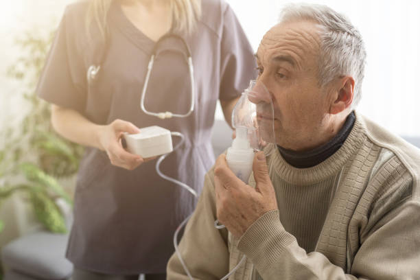 idosos idosos idosos de enfermagem usam dispositivo inalador de oxigênio para ajudar a respirar respiratória. concentrador de oxigênio portátil - nebulizer - fotografias e filmes do acervo