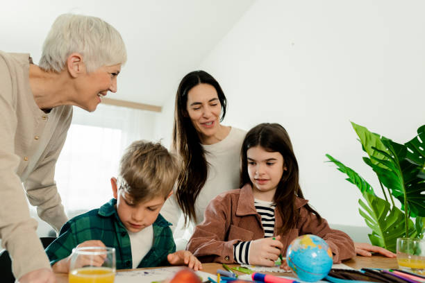 istock Mother and grandmother supporting a boy and a girl while doing homework 1472257923