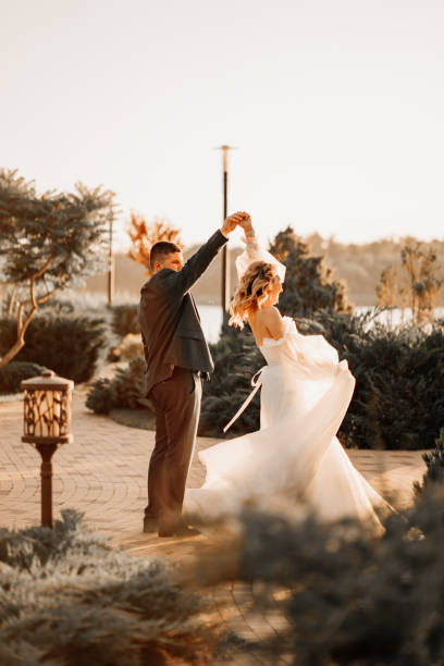 istock dancing happy bride and groom in nature. at sunset 1472258283