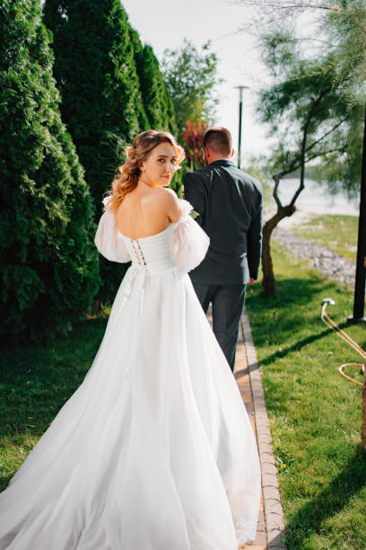istock the groom leads the bride by the hand along the path. 1472259764