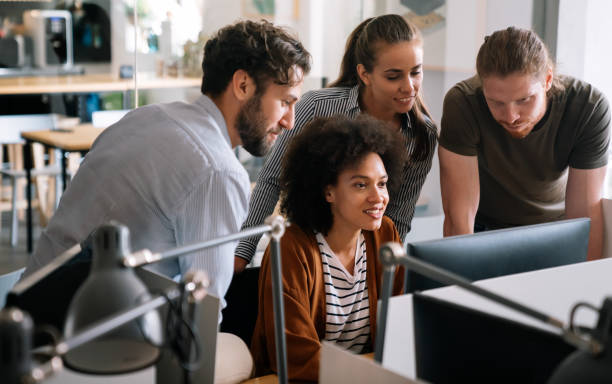 istock Smiling diverse colleagues gather in boardroom brainstorm discuss financial statistics together 1472259856