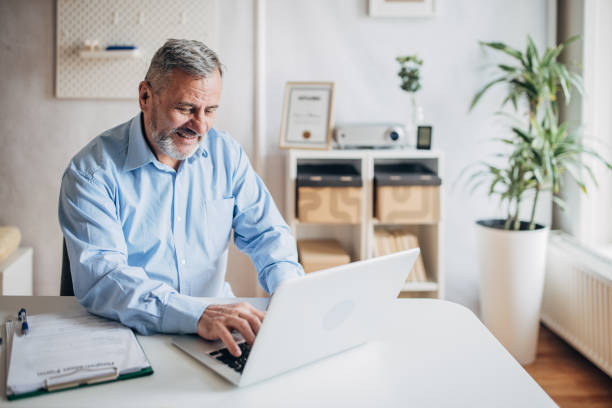 istock Senior businessman using laptop in office 1472262957