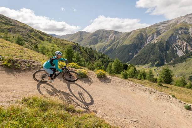 istock Female mountain biker taking speed riding down the mountain on a curve 1472263188