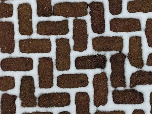 istock Snow patterns on the brown paving stones. 1472264081